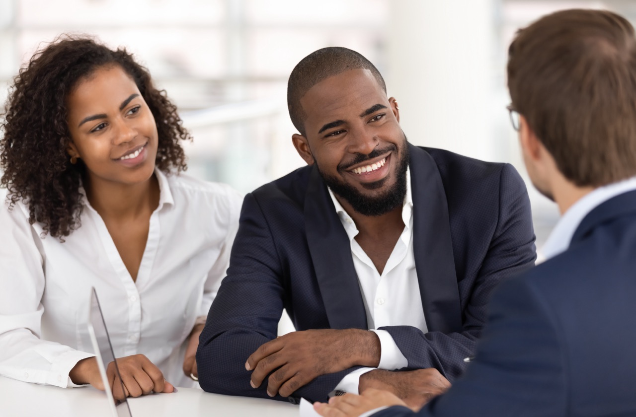 Photo of African American couple speaking with real estate broker