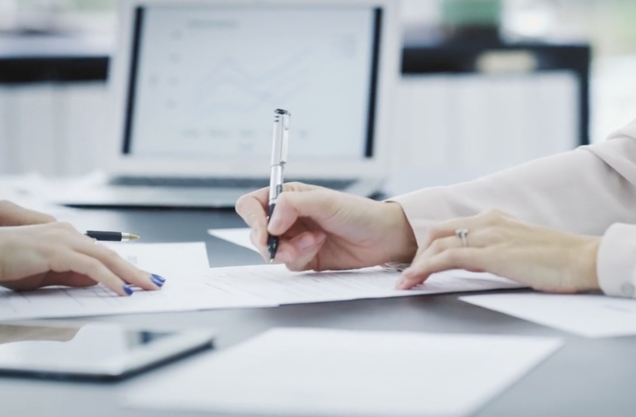 Photo of people signing papers in an office